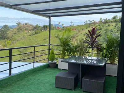 a patio with a table and plants on a balcony at Finca hotel xamai in Guatapé