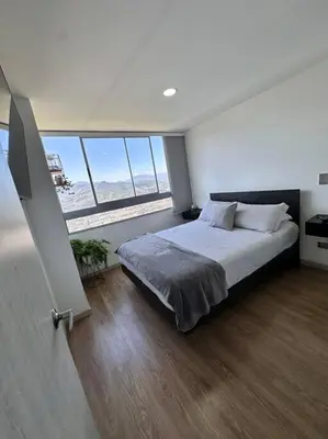 a bedroom with a large bed and a large window at Amazing view Modern Apartment in Sabaneta in Sabaneta