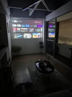 a living room with a table and a large screen at Amazing view Modern Apartment in Sabaneta in Sabaneta