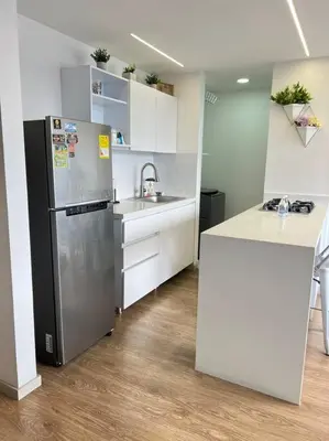 a kitchen with a stainless steel refrigerator and white cabinets at Amazing view Modern Apartment in Sabaneta in Sabaneta