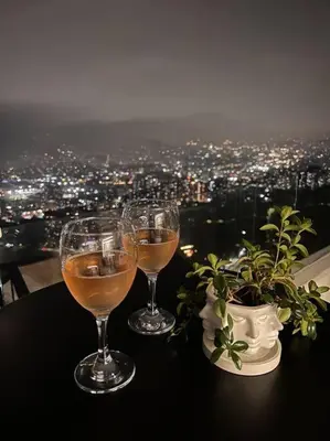 three glasses of wine sitting on a table with a view at Amazing view Modern Apartment in Sabaneta in Sabaneta