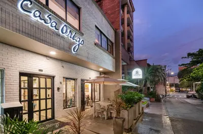 a restaurant with tables and umbrellas outside of a building at Casa Origo Hospedaje in Medellín