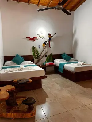 a room with two beds and a bird on the wall at hotel montana Doradal in Doradal