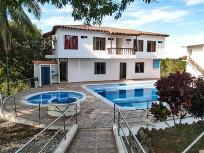 a house with two swimming pools in front of it at hotel montana Doradal in Doradal