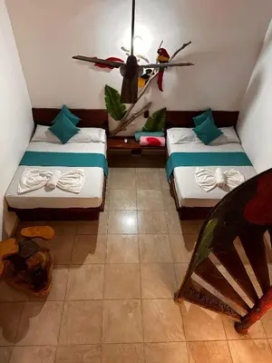 a room with two beds and a ceiling fan at hotel montana Doradal in Doradal