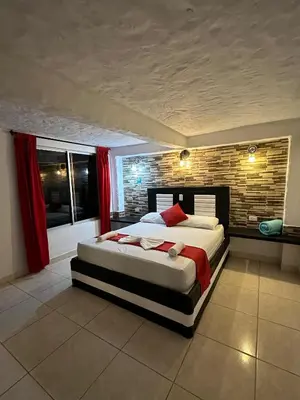 a bedroom with a large bed and a brick wall at hotel montana Doradal in Doradal