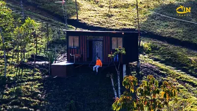 a person sitting in a tiny house on a hill at Refugio Selvatico in Guatapé