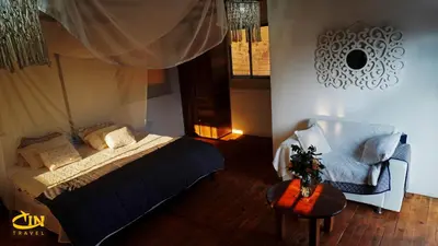 a bedroom with a bed and a chair and a table at Refugio Selvatico in Guatapé