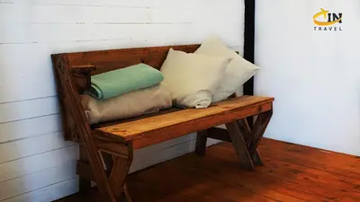 a wooden bench with pillows sitting on it at Refugio Selvatico in Guatapé