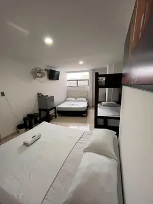 a bedroom with a bed and a room with two bunk beds at Hotel Los Ángeles in Bello
