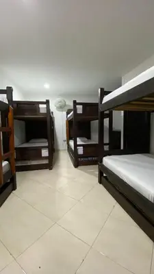 three bunk beds in a room with a tile floor at Hotel Los Ángeles in Bello