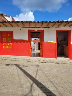 a red and white building with a red door at Casa Nohelia in Jericó