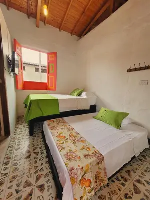a bedroom with two beds and a window at Casa Nohelia in Jericó
