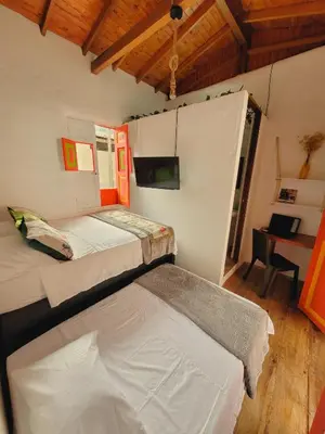 a bedroom with two beds and a desk in it at Casa Nohelia in Jericó
