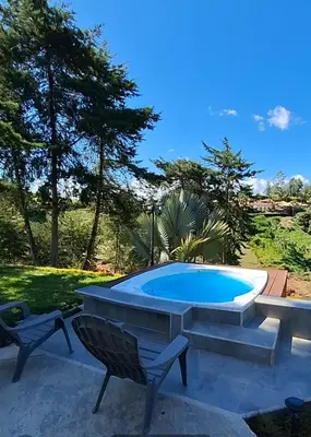 a pool with a table and two chairs next to it at Casa Campestre Guatapé acceso directo a la represa in Guatapé