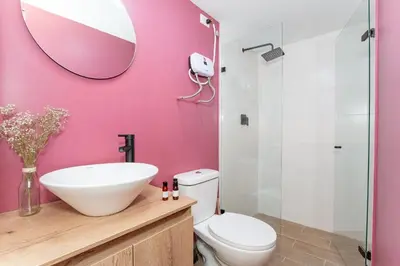 a bathroom with a toilet and a sink and a mirror at 81 Living by Simple Stay in Medellín
