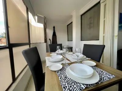 a dining room with a table with plates and wine glasses at Alojamiento turístico laureles, buena ubicación in Medellín