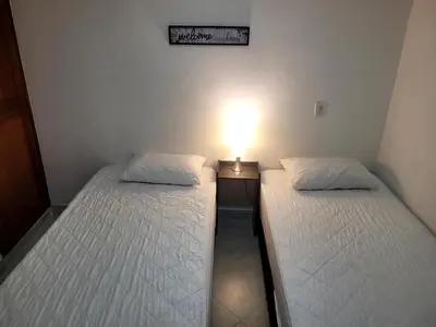 two twin beds in a room with a light on it at Alojamiento turístico laureles, buena ubicación in Medellín