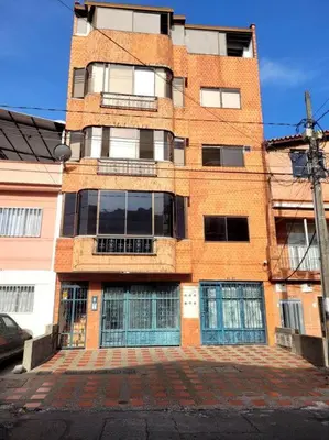 a tall brick building on a city street at Alojamiento turístico laureles, buena ubicación in Medellín