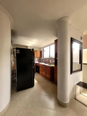a kitchen with a black refrigerator in a room at Alojamiento turístico laureles, buena ubicación in Medellín