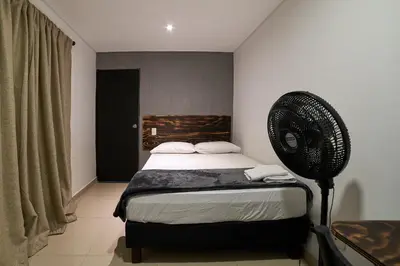a bedroom with a bed and a fan at Farum Hotels in Medellín