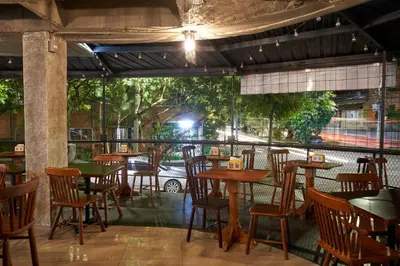 an empty restaurant with wooden tables and chairs at Farum Hotels in Medellín