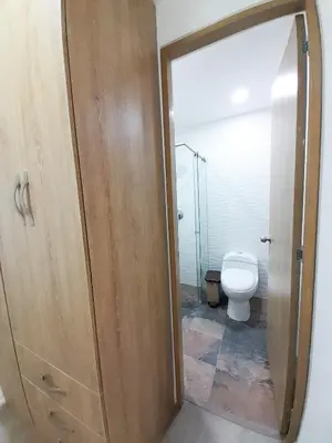 a bathroom with a toilet and a wooden door at MEDELLIN CÓMODOS APARTAESTUDIOS in Medellín