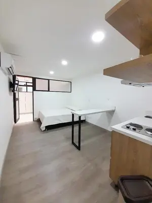 a white room with a bed and a table in it at MEDELLIN CÓMODOS APARTAESTUDIOS in Medellín