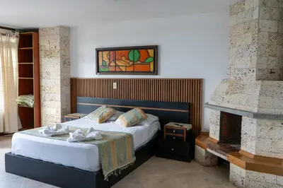 a bedroom with a bed and a fireplace at Hotel Portal Guatapé in Guatapé