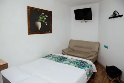 a small room with a bed and a chair at Hotel Portal Guatapé in Guatapé