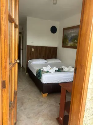a bedroom with two beds and a table in a room at Hotel Portal Guatapé in Guatapé