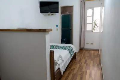 a bedroom with a bed and a television on a wall at Hotel Portal Guatapé in Guatapé