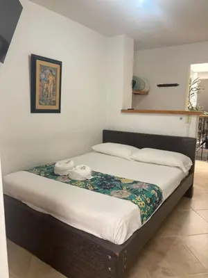 a bed in a room with two towels on it at Hotel Portal Guatapé in Guatapé