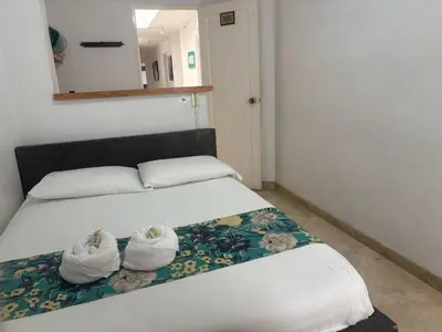 a bedroom with a bed with two white towels at Hotel Portal Guatapé in Guatapé