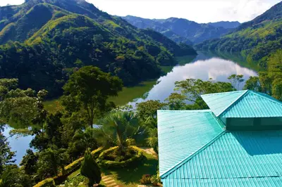 a view of a river and mountains with a blue building at Ecohotel Campo Alegre Norcasia Caldas in Norcasia