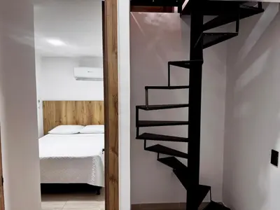 a black spiral staircase in a room with a bed at Apartamentos de lujos para descansar Oasis in San Jerónimo