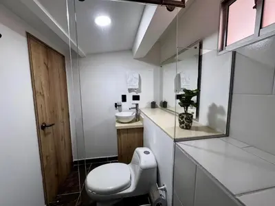a white bathroom with a toilet and a sink at Apartamentos de lujos para descansar Oasis in San Jerónimo