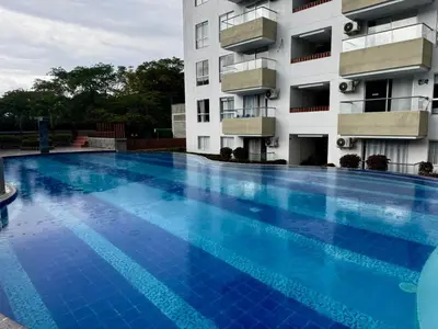 a large blue swimming pool in front of a building at Apartamentos de lujos para descansar Oasis in San Jerónimo