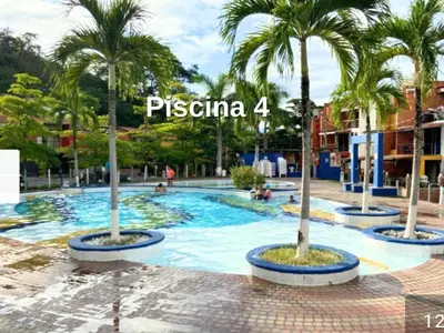 a swimming pool with palm trees in a resort at 