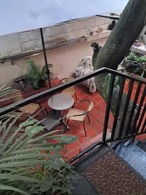 a balcony with a table and chairs on a patio at Hostal Casa Primavera in Medellín