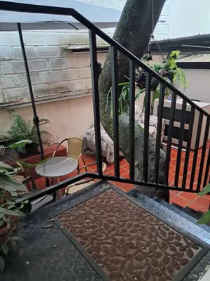 a balcony with a tree behind a fence at Hostal Casa Primavera in Medellín
