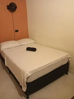 a small bed in a room with a hat on it at Hostal Casa Primavera in Medellín