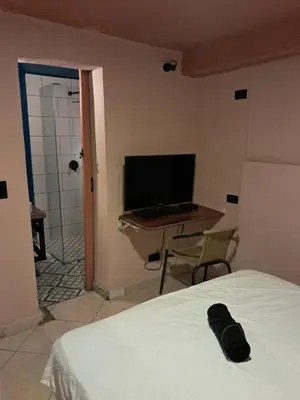 a bedroom with a bed and a desk with a computer at Hostal Casa Primavera in Medellín
