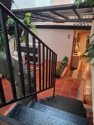 a balcony with a black railing and a staircase at Hostal Casa Primavera in Medellín