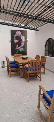 a wooden table and benches in a room with a painting at casa in Medellín