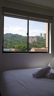 a bedroom with a large window with a view at Apartamento exclusivo en Sabaneta, Antioquia in Sabaneta
