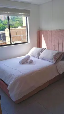 a person laying on a bed in a bedroom at Apartamento exclusivo en Sabaneta, Antioquia in Sabaneta