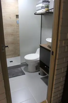 a white bathroom with a toilet and a sink at Excelente Apartamento en Parque El Poblado in Medellín
