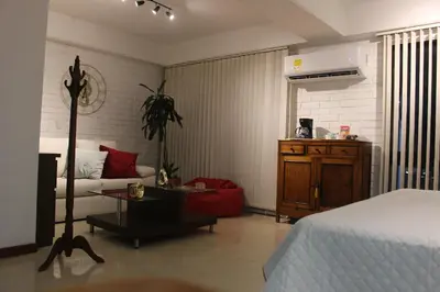 a bedroom with a bed and a living room at Excelente Apartamento en Parque El Poblado in Medellín