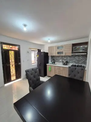 a kitchen with a black table and chairs in it at ECXEPCIONAL y ELEGANTE APARTAMENTO in Medellín